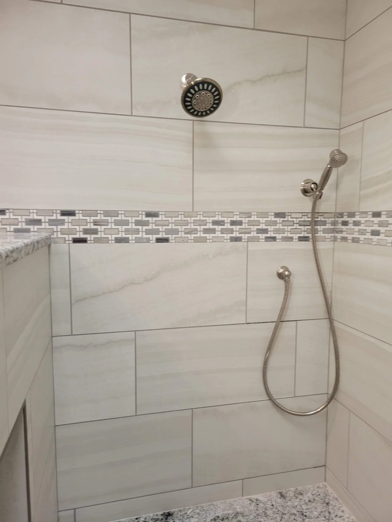 Finished tiled shower with showerhead and handheld shower fixture